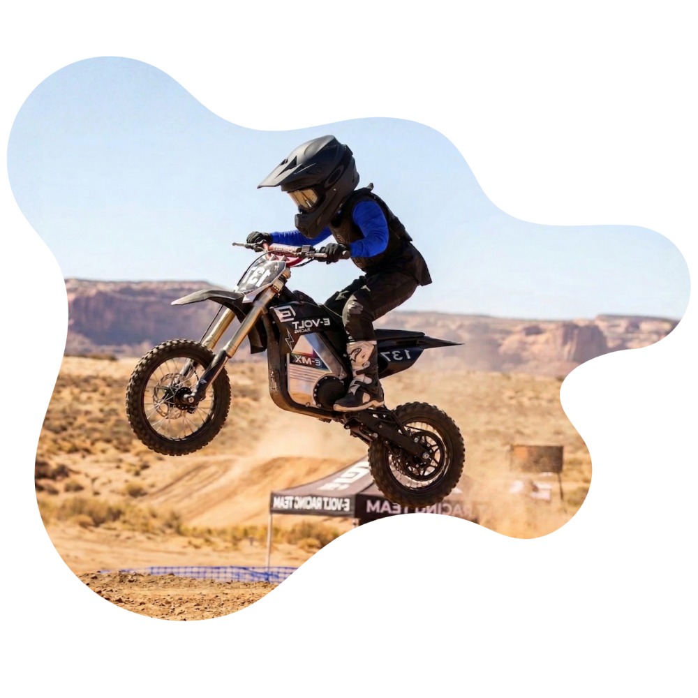 Child on a dirt bike mid-air on a motocross track.