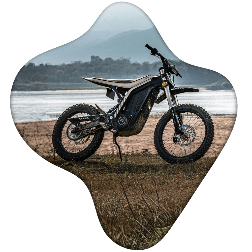 Electric mountain bike parked on grassy terrain by a river.